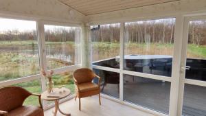 un porche cubierto con mesa y sillas en Axelgaard Nature Suite, en Hennebjerg