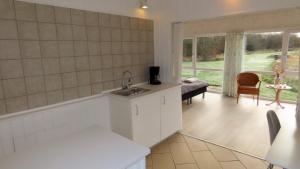 a kitchen with a sink and a living room at Axelgaard Nature Suite in Hennebjerg