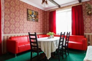 カメンスク・シャフチンスキーにあるGuest House Pegasのダイニングルーム(テーブル、赤い椅子付)