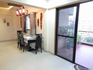 a dining room with a table and chairs and a window at MajickMoments Hadapsar-Magarpatta Pune in Pune