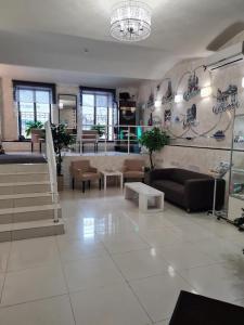 カザンにあるHotel Karatのソファとシャンデリア付きの広いリビングルーム