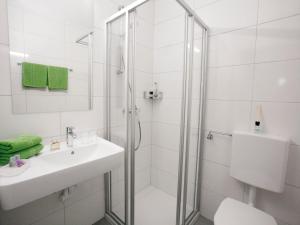 a bathroom with a shower and a sink and a toilet at Strandpension Seejuwel in Sankt Kanzian