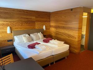 a bedroom with a bed with two towels on it at Hotel Berghaus Stuben in Stuben am Arlberg