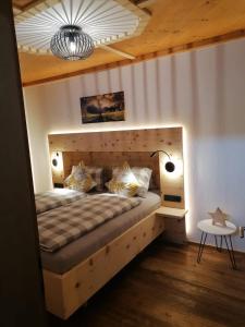a bedroom with a large bed with a wooden headboard at Apartment Moosbach in Fieberbrunn