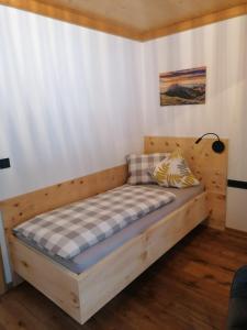 a bedroom with a wooden bed with a checkered mattress at Apartment Moosbach in Fieberbrunn