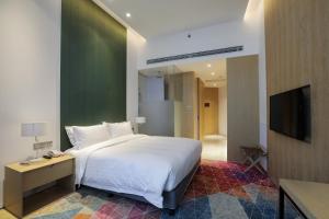 a bedroom with a large bed and a television at Holiday Inn Express Shanghai Songjiang Fangta by IHG in Songjiang