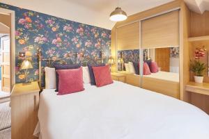 a bedroom with a large bed with a floral wallpaper at Host & Stay - Great Habton Cottage in Malton