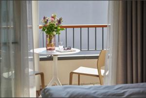 a table with a vase of flowers on a balcony at Kaiser 4 in Norderney