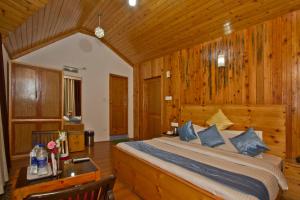 une chambre avec un lit et un mur en bois dans l'établissement THE CEDAR VILLA AND APARTMENT,Bonefire,Cook,Helper,Kitchen,Lawn,Parking,5 min Drive Mall road, à Manali