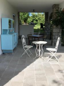 a patio with a table and chairs and a table at La Piana Dei Castagni in Castel dʼAiano