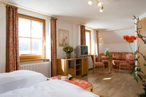 a bedroom with a bed and a living room at Landgasthaus Engel - Naturparkwirt in Höchenschwand