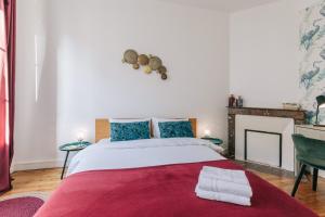 une chambre avec un grand lit avec une couverture rouge dans l'établissement LIK APPARTS Gare Rennes - Appart LE HERON, à Rennes