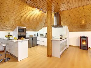 Il comprend une cuisine avec des comptoirs blancs et un plafond en bois. dans l'établissement Casa Leão de Ouro by LovelyStay, à São Jorge