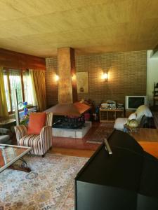 a living room with a tv and a room with a fireplace at Casa Etna in Rascafría