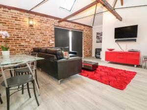 a living room with a couch and a table and a red rug at 4 Holt Court in Salisbury
