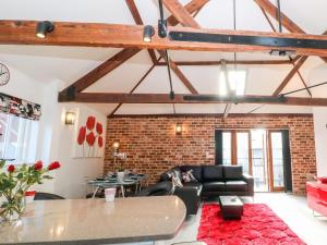 a living room with a brick wall at 4 Holt Court in Salisbury