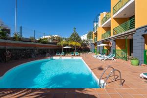 a swimming pool in the middle of a building at Apartamentos Cordial Judoca Beach in Playa del Ingles