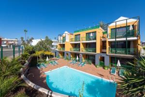 a hotel with a swimming pool in front of a building at Apartamentos Cordial Judoca Beach in Playa del Ingles