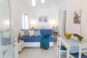 Un pequeño dormitorio con una cama azul y una mesa en Acrothea Suites and Villas en Akrotiri