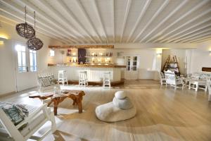 a living room with a ceiling with a table and chairs at Erato Hotel Mykonos in Ornos