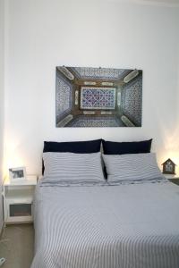 a bedroom with a bed with a picture on the wall at Villa Giulia in Ostuni