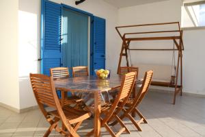 uma sala de jantar com uma mesa de madeira e cadeiras em Villa Giulia em Ostuni