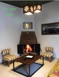 sala de estar con chimenea, mesa y sillas en Bar Suites en Tandil