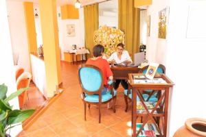 two people sitting at a table with a laptop at Casa Rural Don Lope en Priego de Córdoba in El Cañuelo
