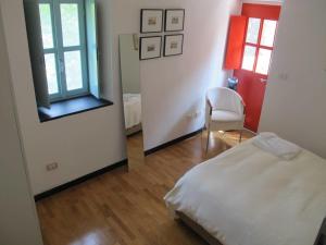 Castelbianco的住宿－Castello stunning property，一间卧室配有一张床、镜子和椅子