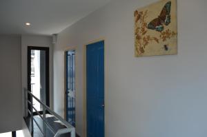 a room with a blue door and a picture of a butterfly at Varinda Hostel in Bangkok