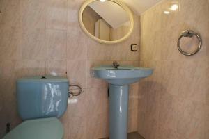 a bathroom with a toilet and a sink and a mirror at Holidays Domus Iano in Esparraguera