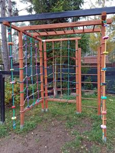 a playground with a wooden structure with a climbing frame at dom całoroczny na Kaszubach Nietoperek, prywatna balia, bania ruska, prywatna sauna in Załakowo