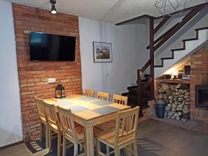 een eetkamer met een tafel en stoelen en een open haard bij dom całoroczny na Kaszubach Nietoperek, prywatna balia, bania ruska, prywatna sauna in Załakowo