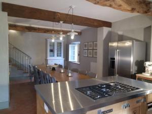 cocina con nevera de acero inoxidable y mesa en Luxury 6-bed Tuscan Villa near Lucca, en Castelvecchio