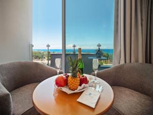 a table with a bowl of fruit and wine glasses at Avlida Hotel in Paphos