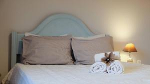 uma cama branca com uma cabeceira e almofadas azuis em Casa das Flores em Santo Tirso