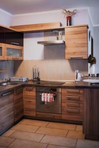 a kitchen with wooden cabinets and a stove at Fotuso House in Majdany Wielkie