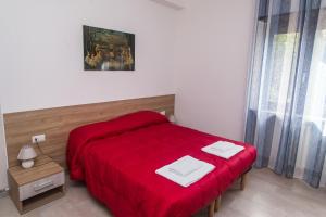 a bedroom with a red bed with a red blanket at B&B Al Ponte in Potenza