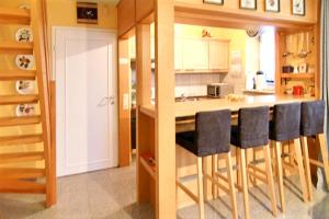 a kitchen with a counter and a bar with bar stools at Modern Apartment in Westerland-Sylt, 50 sqm, close to beaches in Westerland (Sylt)