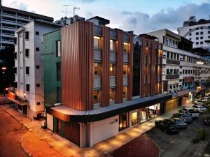 un edificio en una calle de la ciudad con coches aparcados en The Seraya Hotel, en Kota Kinabalu