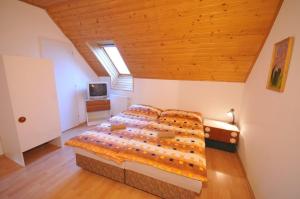a bedroom with a large bed with a wooden ceiling at Penzión Belvia in Nová Lesná