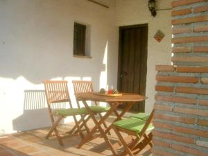 Une table et des chaises en bois sont disponibles sur la terrasse. dans l'établissement 3 bedrooms house with private pool furnished terrace and wifi at El Borge, à Borge