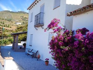 a white building with purple flowers in front of it at Charming House with Pool in El Borge in Borge