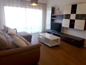 a living room with a couch and a tv at 2 bedrooms appartement with shared pool terrace and wifi at Portimao 5 km away from the beach in Portimão