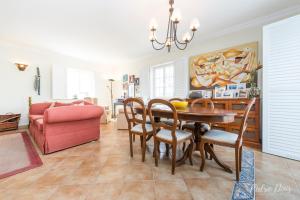 ein Esszimmer mit einem Tisch und einem rosa Sofa in der Unterkunft Elegant Villa in Azeitão with Pool in Azeitão