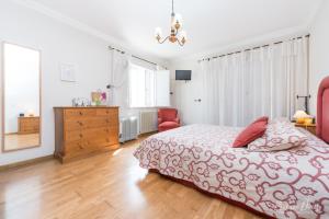 Schlafzimmer mit einem Bett, einer Kommode und Fenstern in der Unterkunft Elegant Villa in Azeitão with Pool in Azeitão + 21 Fotos