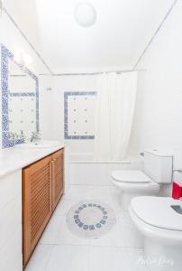 a white bathroom with a toilet and a sink at 4 bedrooms villa with private pool enclosed garden and wifi at Azeitao in Azeitao