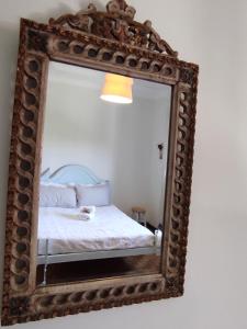 a mirror with a bed in a room at Casa das Flores in Santo Tirso