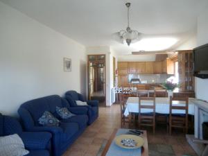 a living room with a blue couch and a table at Seaside Villa in Pataias with Private Pool in Pataias