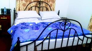 a bedroom with a bed with a blue comforter at Inviting 2-Bed House Komakundi Rural Kilimanjaro in Kimangaro